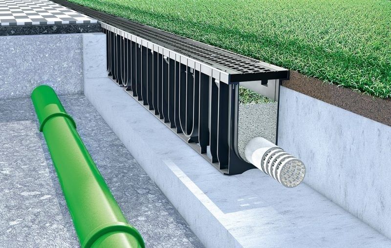 Cutaway view of artificial turf drainage channel and outlet pipe