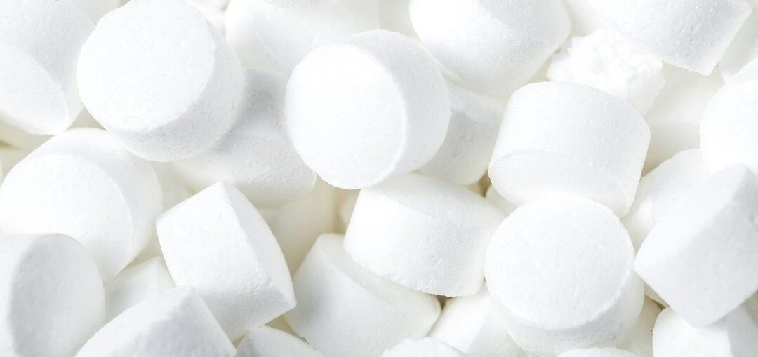 Close-up of white cylindrical water-softener salt tablets