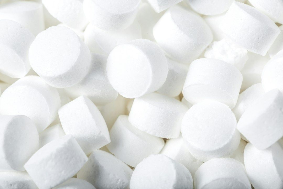 Close-up of white cylindrical water-softener salt tablets